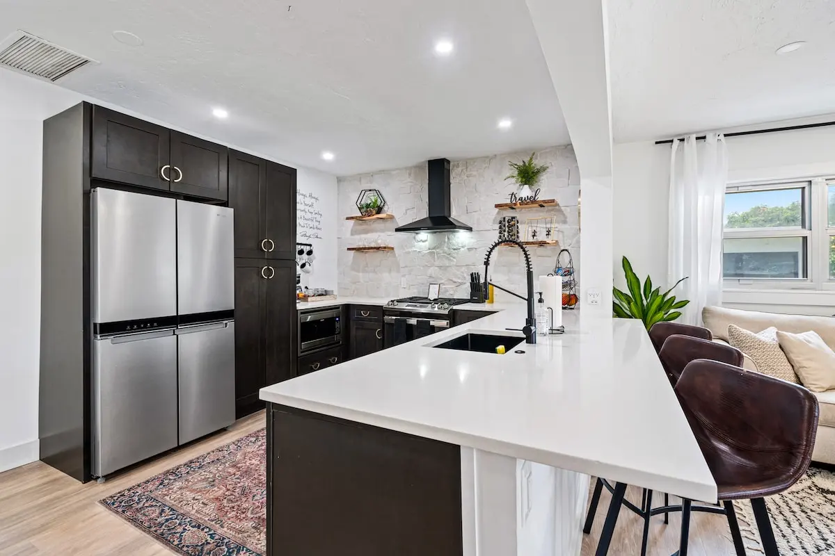Fully stocked and ready to go — enjoy modern appliances, deep drawers, open shelving, and a breakfast bar that seats 3. Cook like you're home (but better).