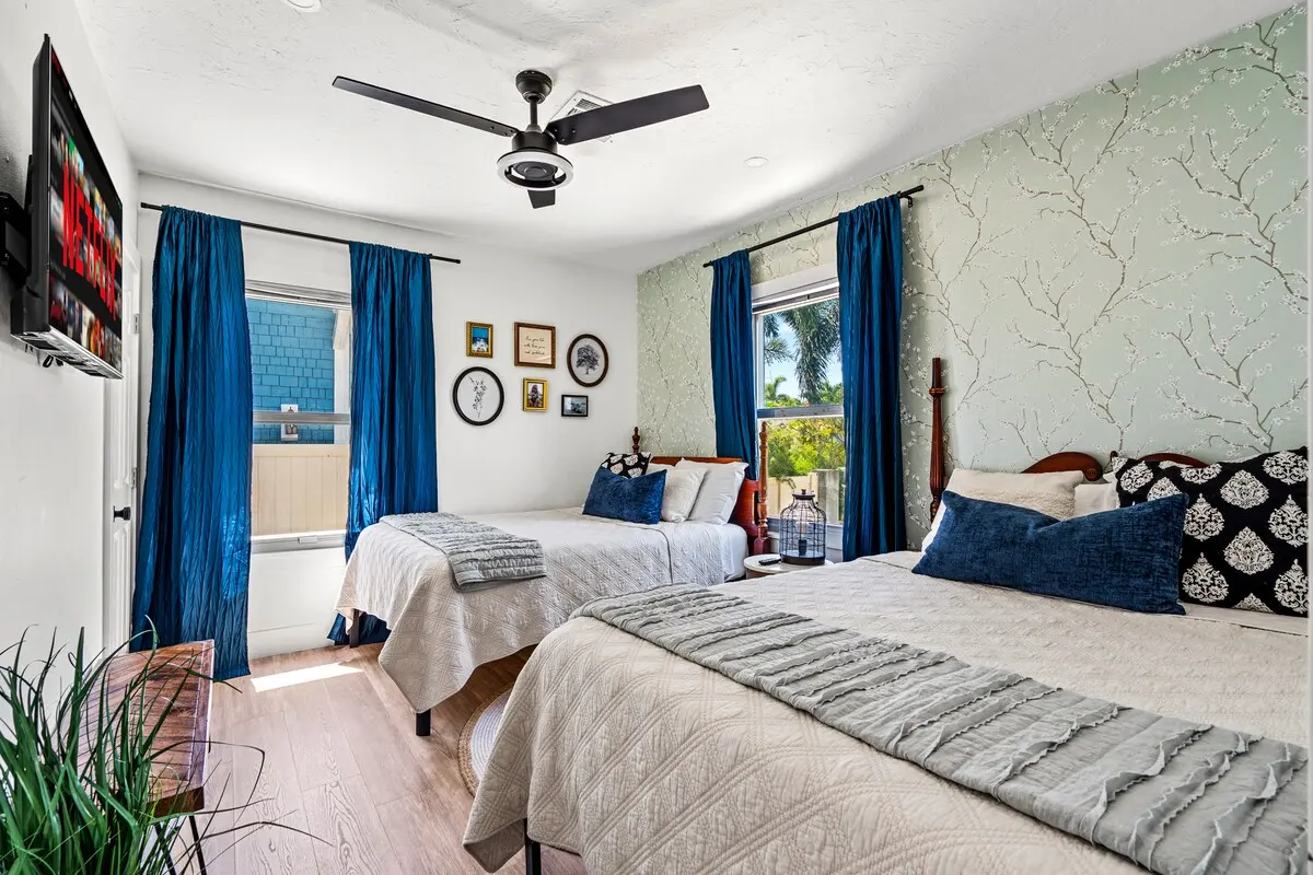 Stream, snooze, repeat. Each bed is topped with plush linens, and there’s a smart TV ready for your Netflix binge. Bonus: peep that whimsical wallpaper!