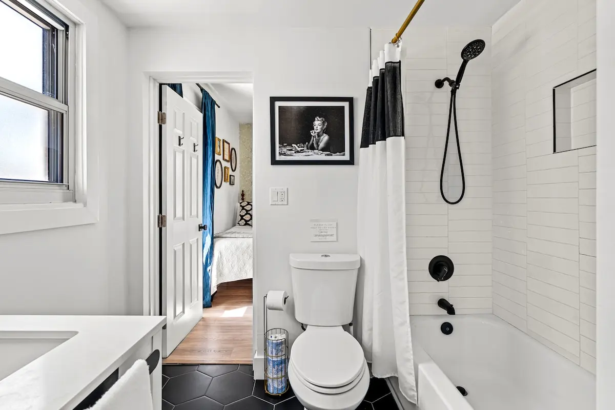This clean, crisp bathroom connects to both bedrooms and keeps the Marilyn vibes going strong — with a rainfall showerhead and spa-worthy simplicity.