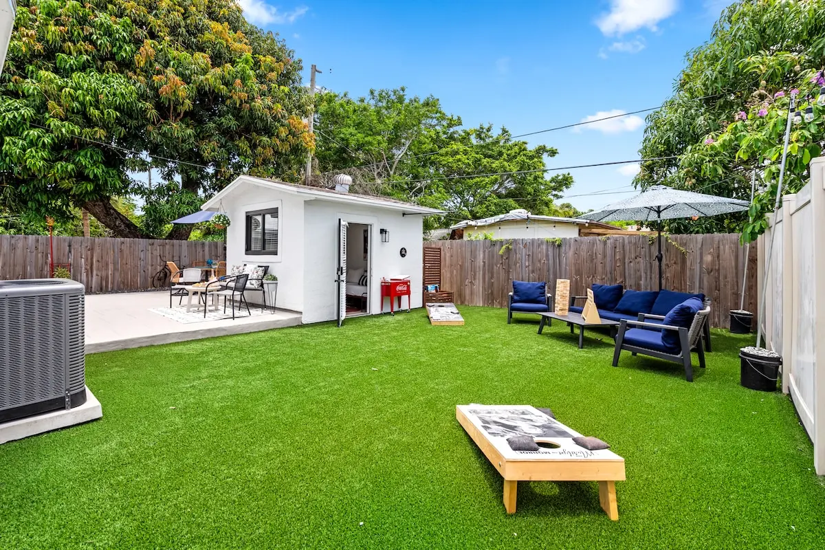Let the games begin! This dreamy backyard features lawn games, stylish seating, and a chic guest suite steps away. Cornhole tourney, anyone?